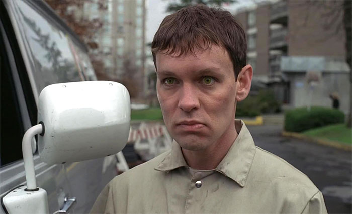 Doug Hutchison looking suspiciously at someone near a car 