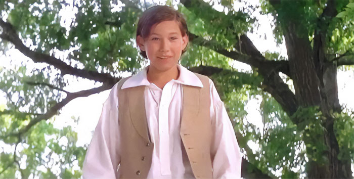 Jonathan Taylor Thomas standing in a forest 