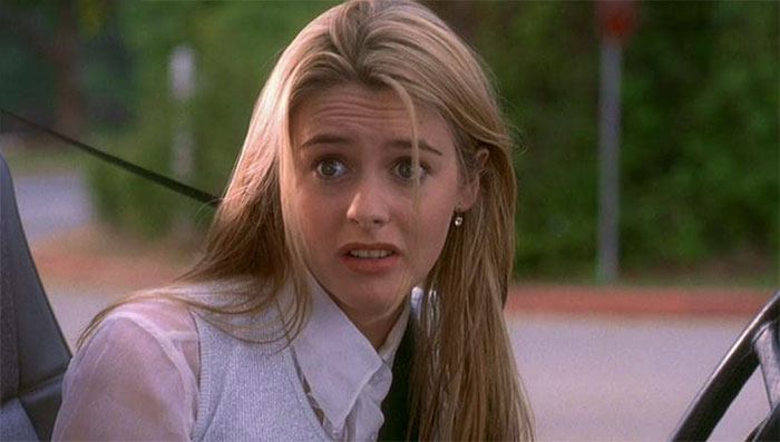 Alicia Silverstone looking at someone while sitting in a car 