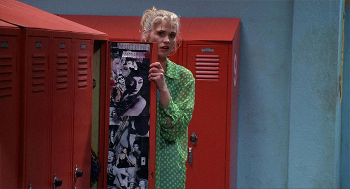 Sarah Michelle Gellar standing behind a locker door 
