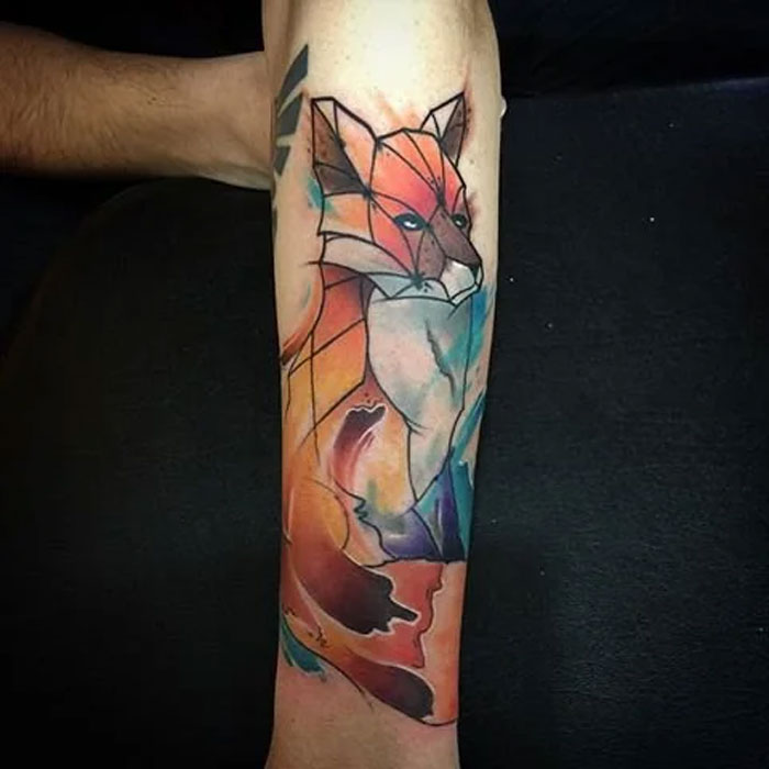 Geometric fox tattoo on forearm, featuring vibrant colors and sharp lines, showcasing creative design.