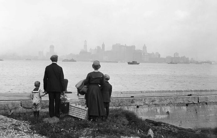 Una familia de inmigrantes en el muelle de la isla de Ellis, después de haber pasado el riguroso examen de entrada en el país, mirando hacia el horizonte de Nueva York mientras esperan el ferry del gobierno, el 13 de agosto de 1925