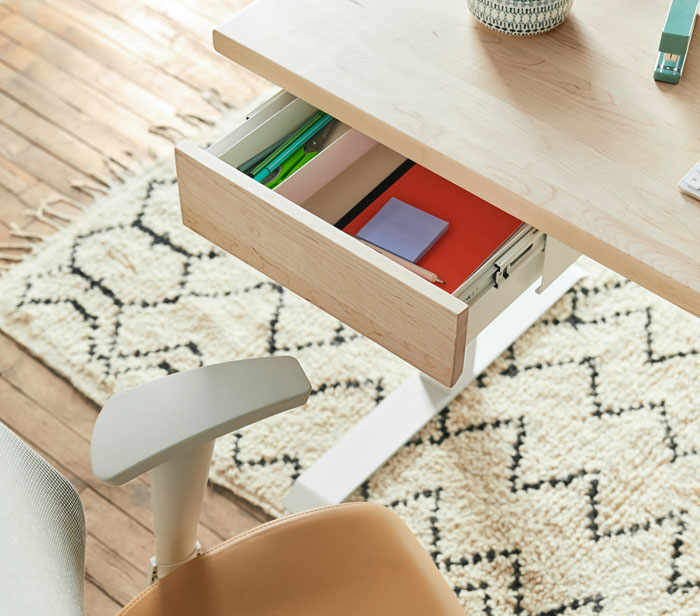 Open desk drawer with organized stationery items, illustrating home organization ideas.