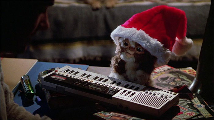 Gremlin wearing Santas' hat playing the piano 