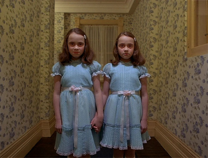 Twins holding hands in the hallway 