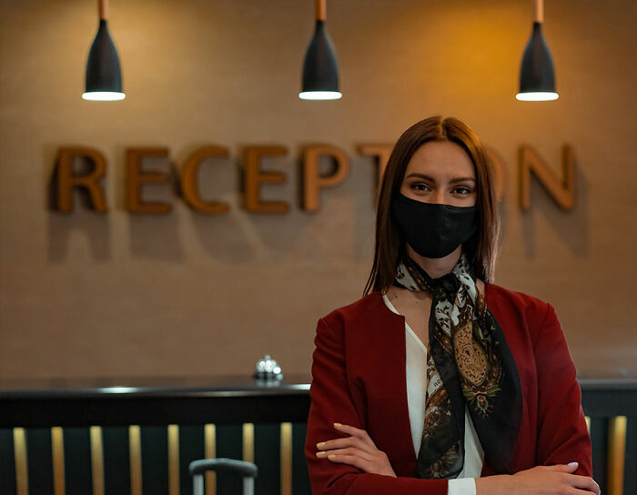 Receptionist in hotel wearing red suit
