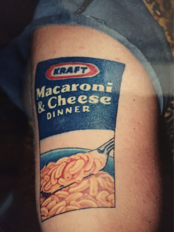 Tattoo of Kraft Macaroni & Cheese box on arm, showcasing unique design.