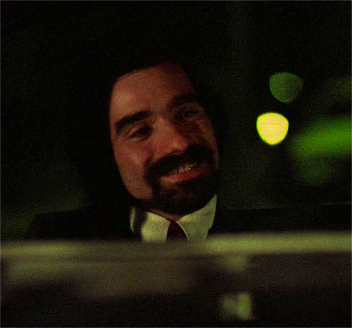 Martin Scorsese sitting and smiling in movie Taxi Driver