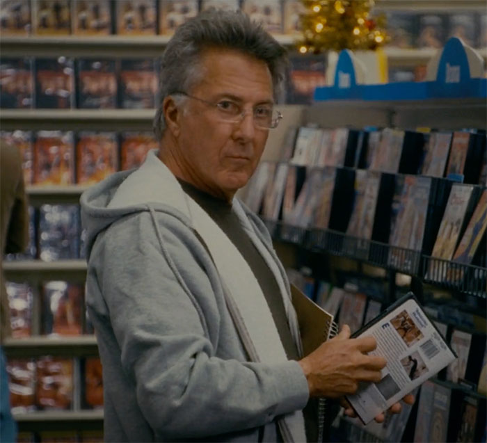 Dustin Hoffman holding movie disc in hand in movie The Holiday