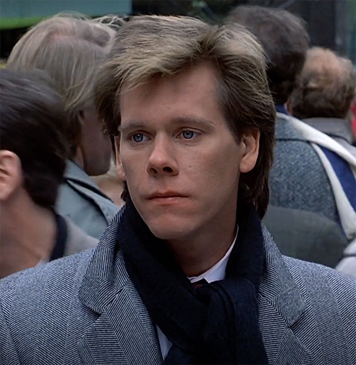 Kevin Bacon standing and looking in movie Planes, Trains and Automobiles
