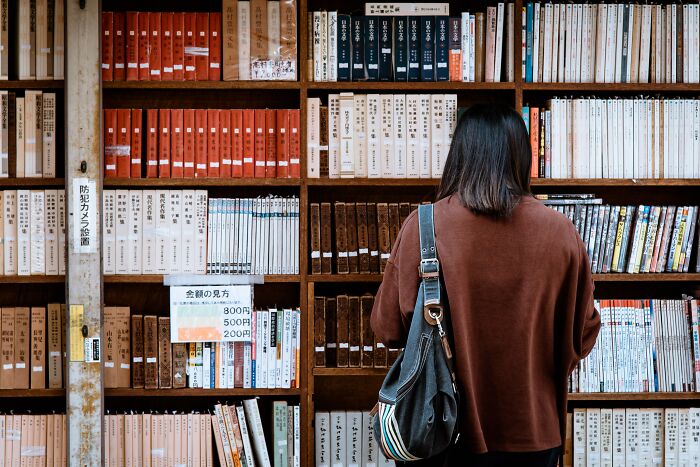 Woman Picking Books In Library 