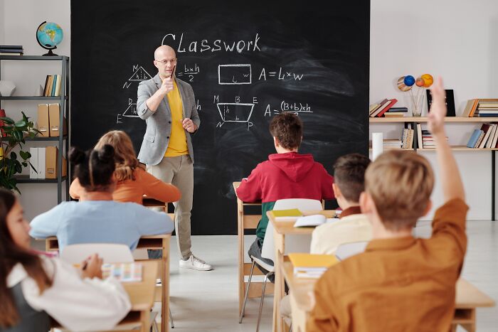 Kid raising hand in the classroom 