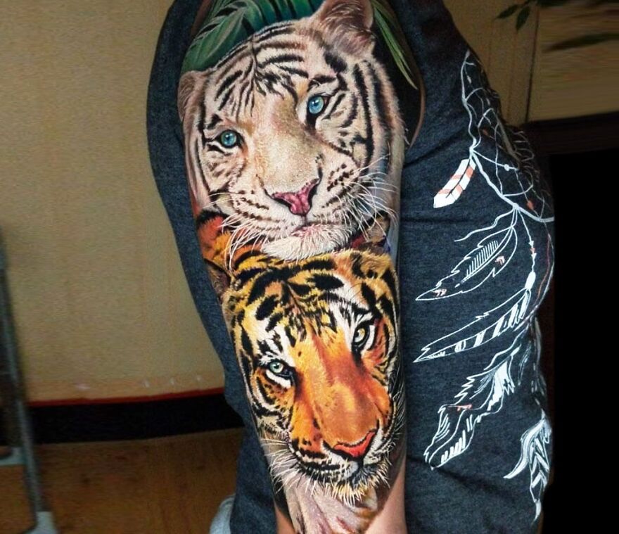 Realistic tiger heads tattoo on arm, showcasing incredible detailing and artistry.
