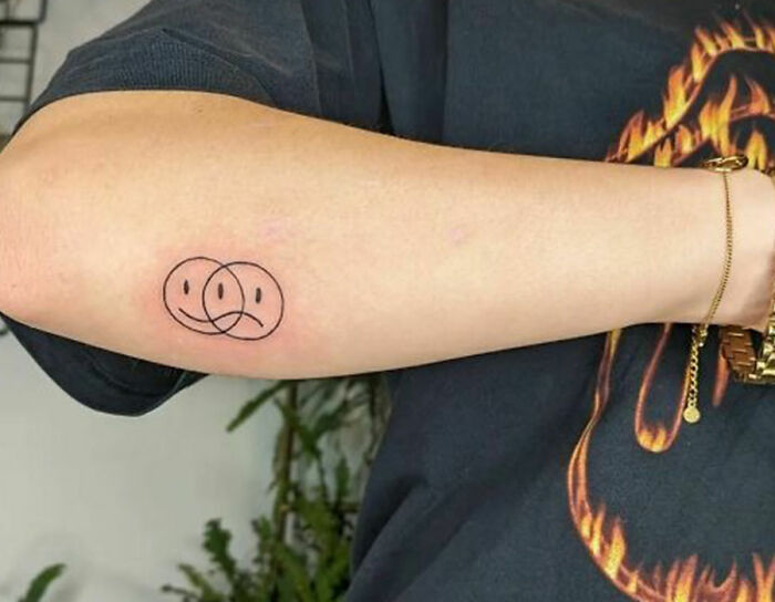 happy and sad smile face arm tattoo