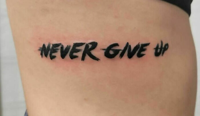 "Never Give Up" phrase tattoo 