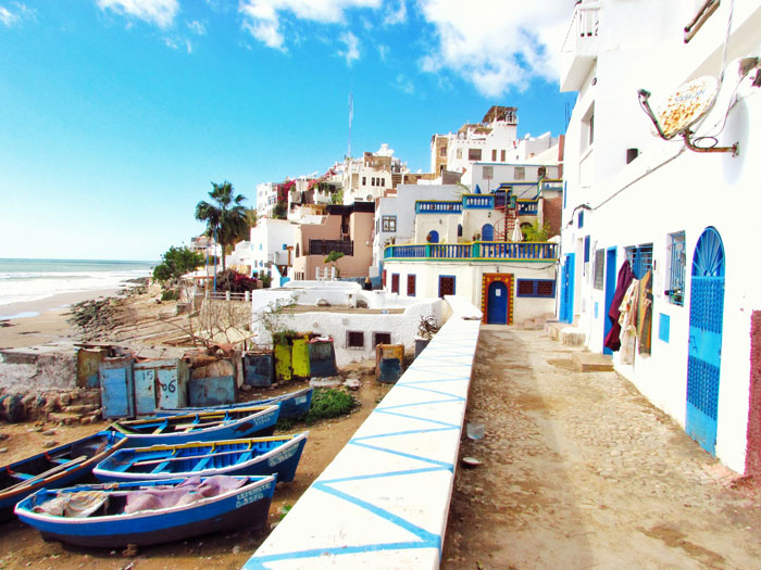 Boats docked near white and blue houses
