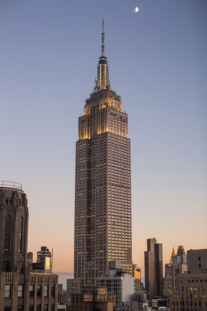 Picture of Empire State Building at sunset near other buildings
