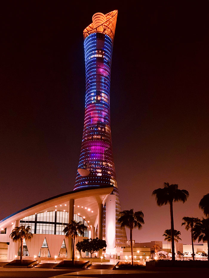 Picture of The Torch tower at night near other buildings