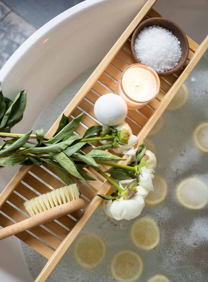 Spa bath with flowers, salt, and lit candle
