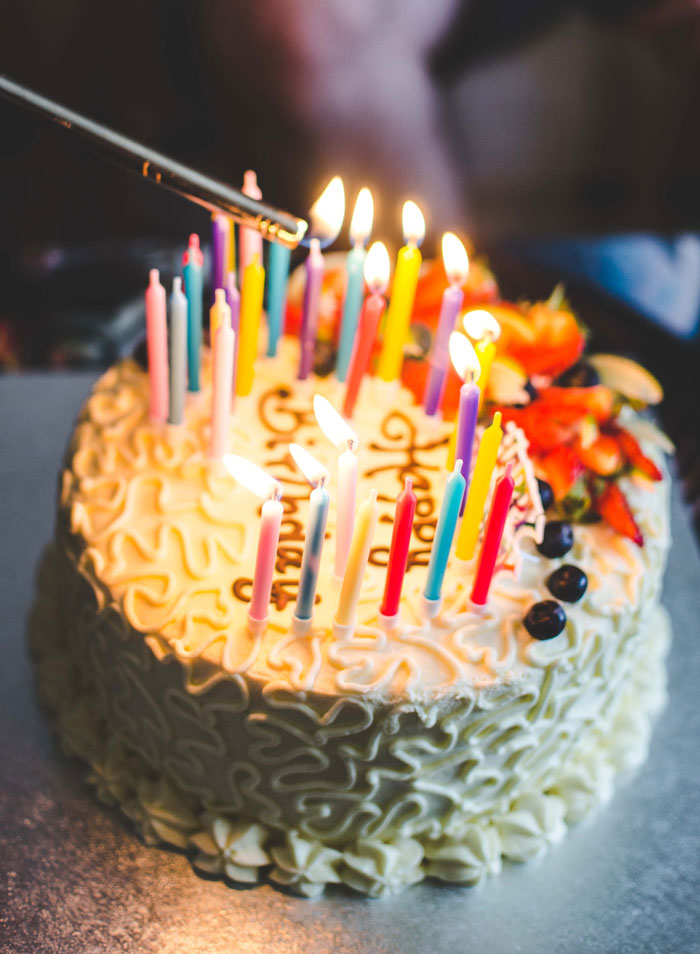 Birthdate cake with many lit colorful candles