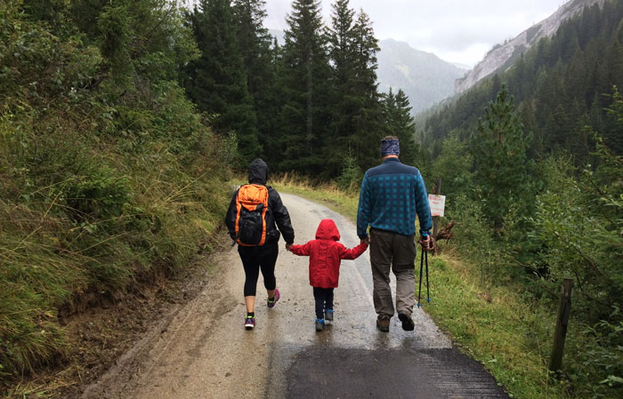 Three-person family walking on the mountain road