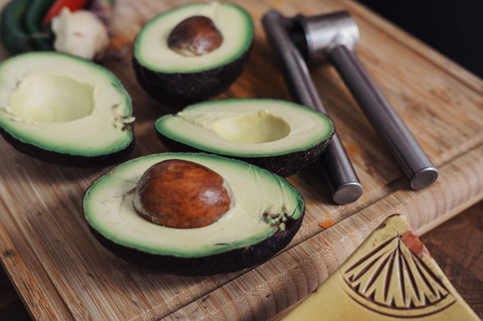 Two split avocados on a wooden table
