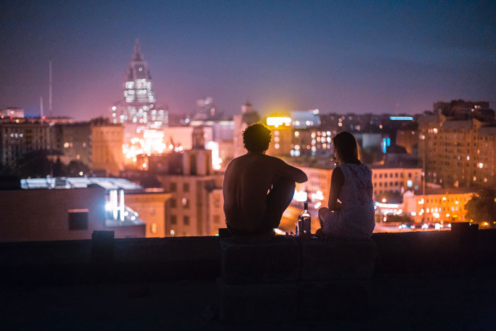 A couple on roof sitting and watching the night view