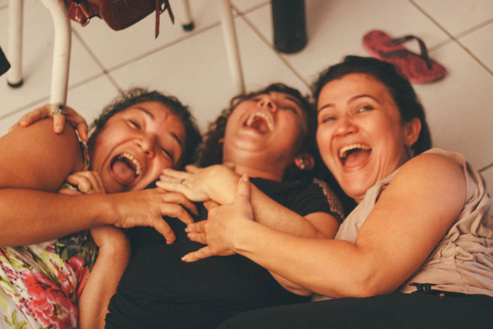 Three women lying on the ground and laughing