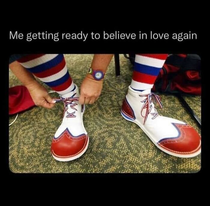 Person tying large clown shoes, captioned about believing in love again, representing a single life meme.