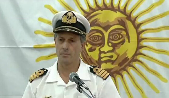 Parece como si el sol estuviera dándole un masaje en los hombros a un oficial de la marina 