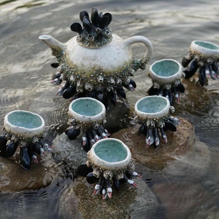 Nature-inspired ceramics resembling ocean creatures on rocks, featuring a teapot and matching cups.