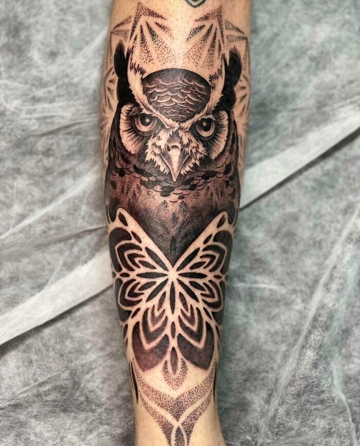 Geometric tattoo of an owl and butterfly design on a forearm, showcasing intricate patterns and details.