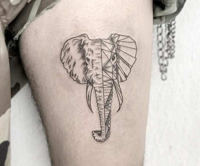 Geometric tattoo of an elephant, half realistic and half composed of geometric shapes, inked on a person's leg.