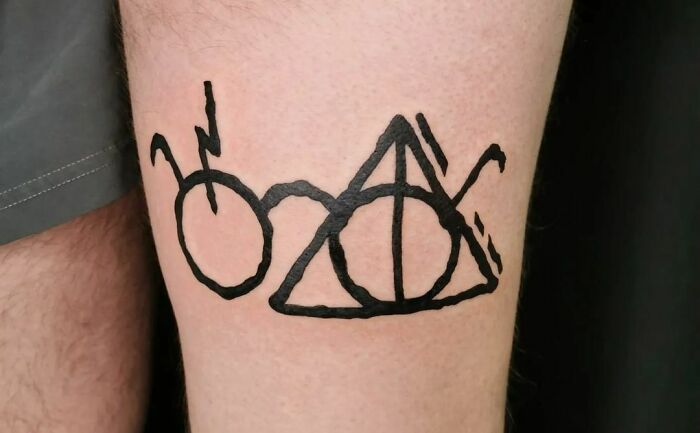 Harry Potter tattoo featuring iconic symbols, black ink on skin.
