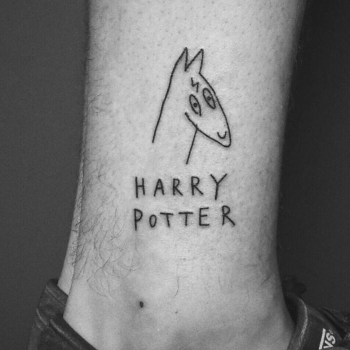 Simple Harry Potter tattoo featuring a doodle of Harry's face with glasses and lightning scar above text "Harry Potter".