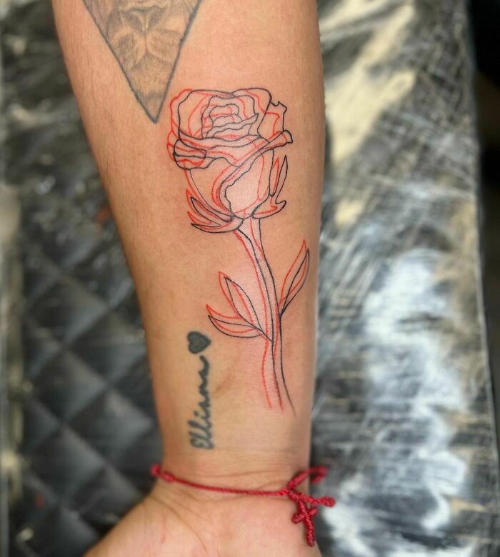 Red and black rose arm tattoo 