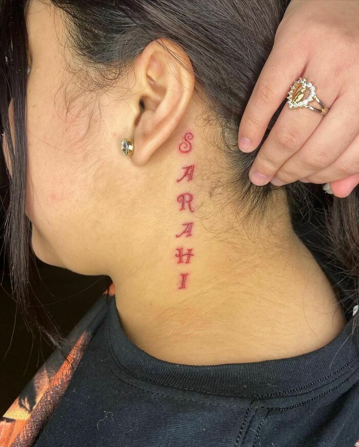 "Sarah" inscription behind the ear tattoo