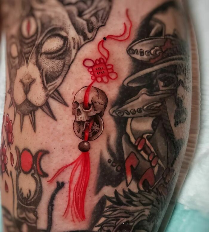 Skull and red rope tattoo 