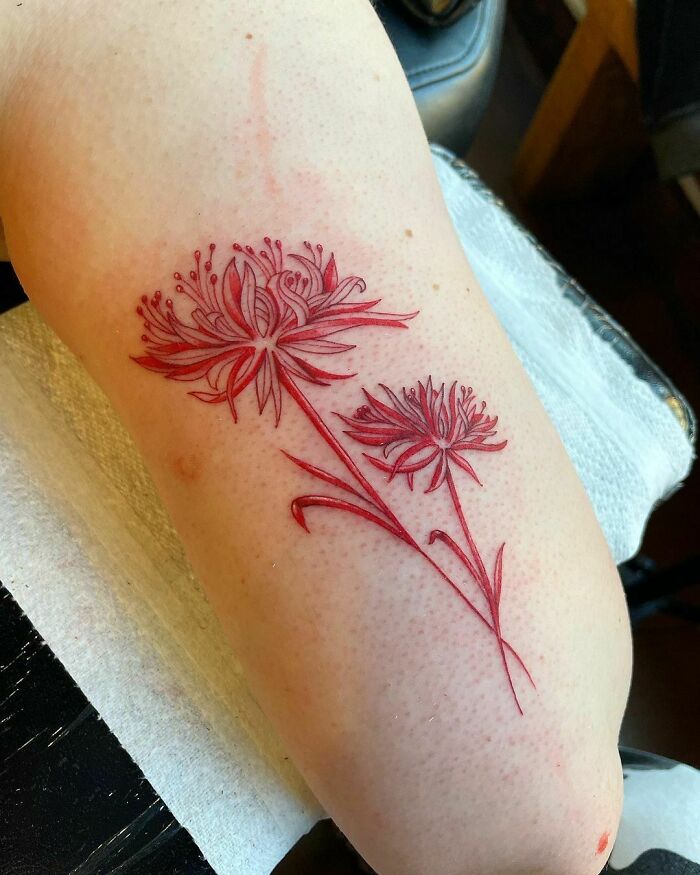 Red flowers arm tattoo 