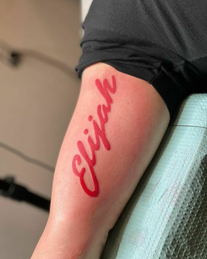 Red ink name tattoo 