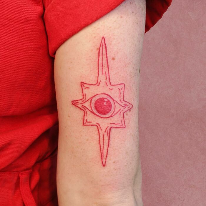 Red eye arm tattoo 