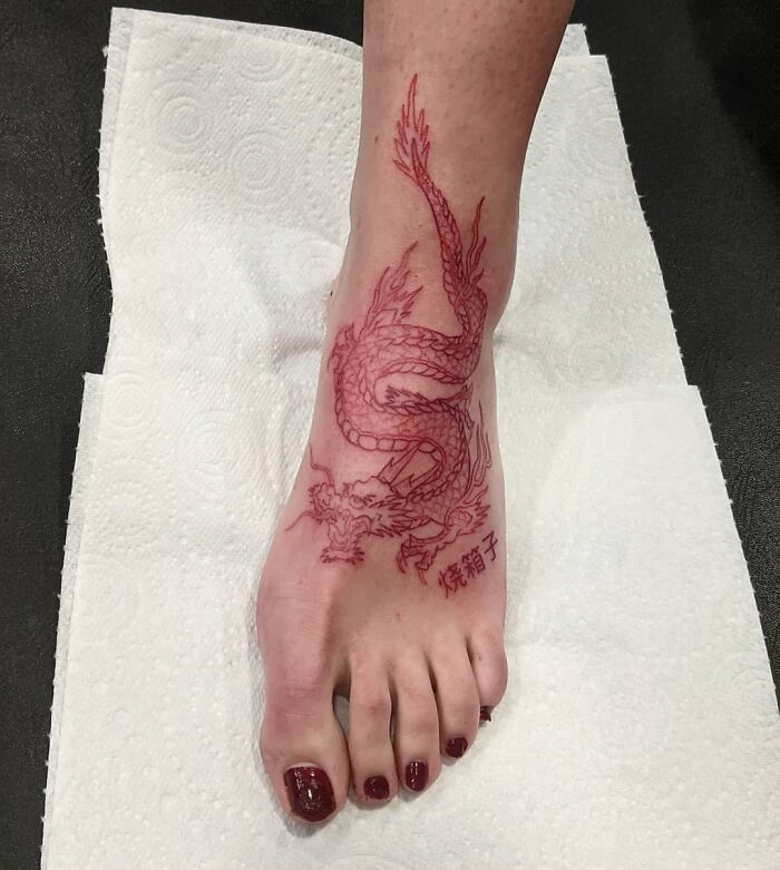 Red Ink Dragon Tattoo On A Foot
