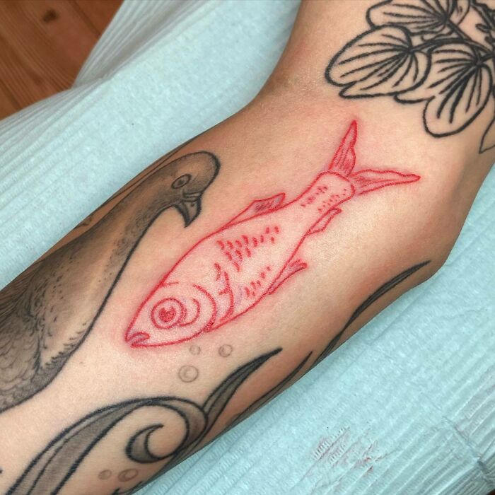 Red fish arm tattoo 