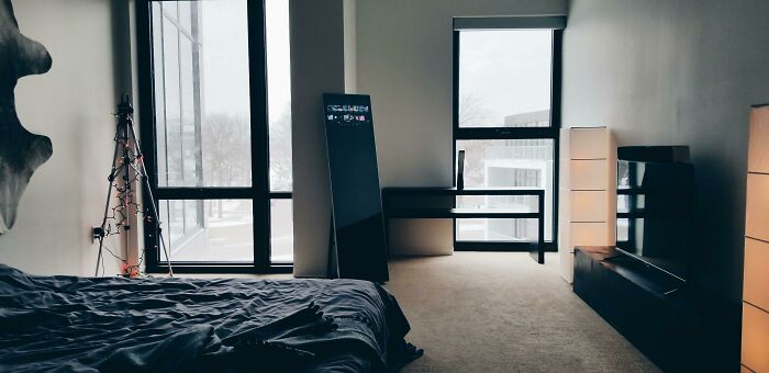 Modern bedroom decoration with a sleek design, featuring a minimalist desk, decorative lights, and large windows for creative inspiration.