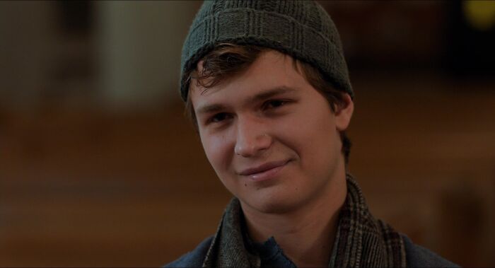 Augustus wearing grey hat and crying 