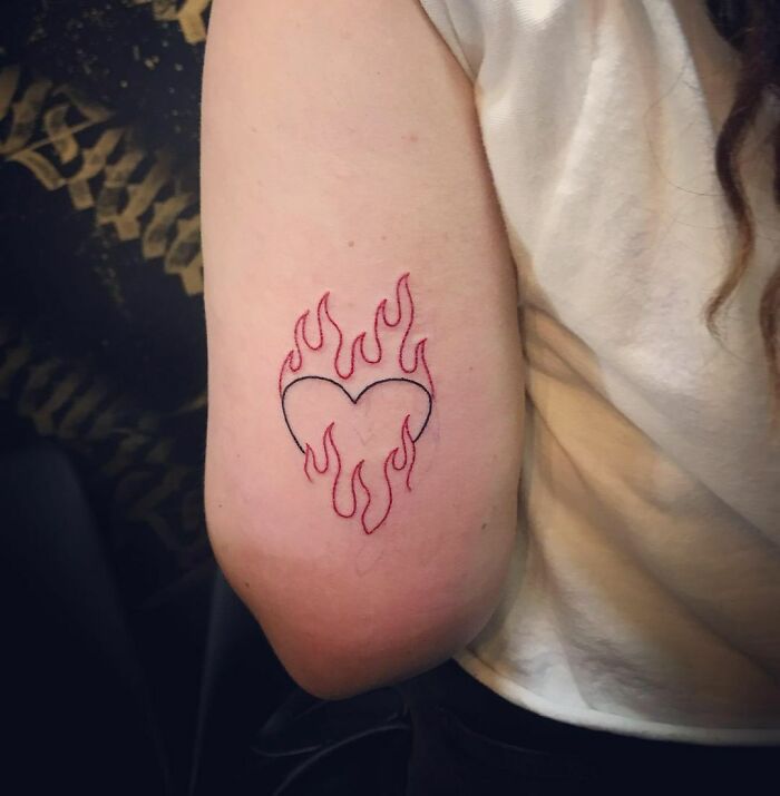 Black heart and red flames tattoo 