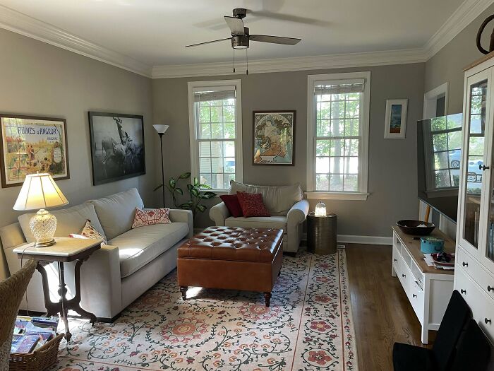 Cozy living room with creative decoration ideas, featuring a sofa, armchair, and artwork on the walls.