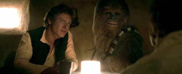 Iconic best friend duo sitting together in a dimly lit room, sharing a moment over drinks.