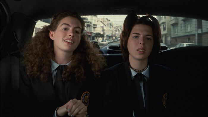 Two people in school uniforms sitting in a car, representing an iconic best friend duo.
