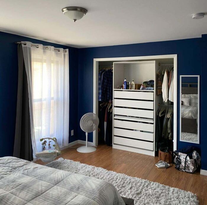 Creative bedroom with blue walls, modern decor, white closet, and stylish mirror for decoration inspiration.
